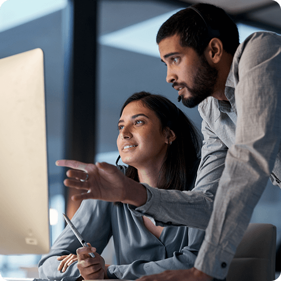 Two people working in front of a computer