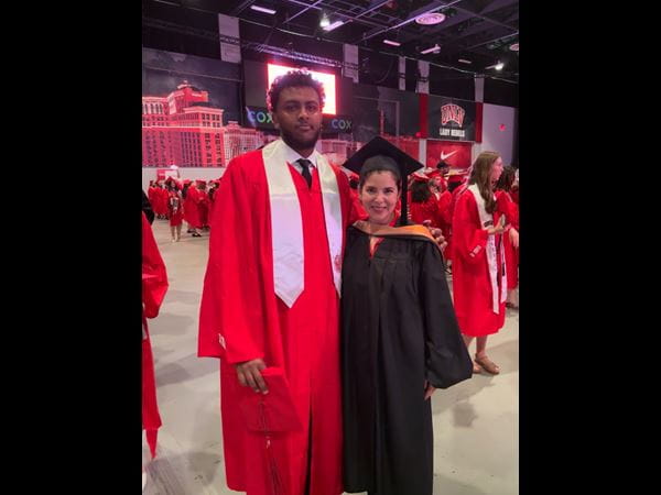 A group of people gathered around a table displaying an ISACA sign, engaged in discussion or collaboration.