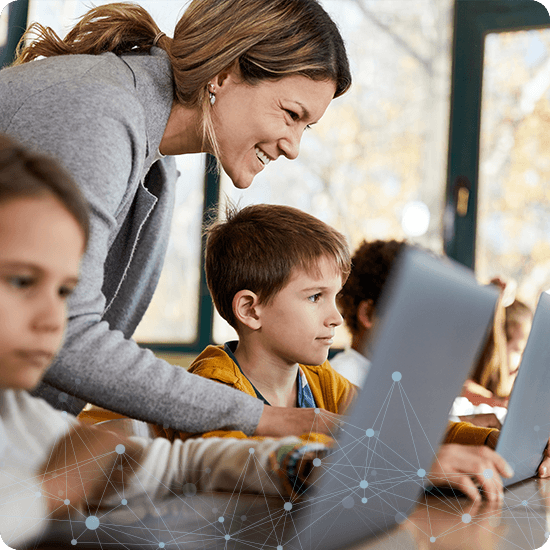 A woman and two children are focused on their laptops, engaged in a learning activity together.