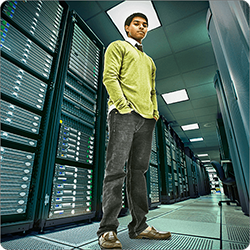 Man standing in front of wall of computers