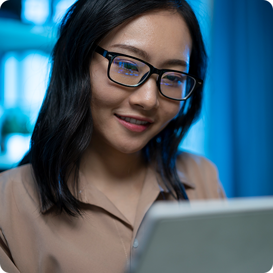 A woman with glasses, looking thoughtfully to the side, showcasing her stylish eyewear and confident expression.