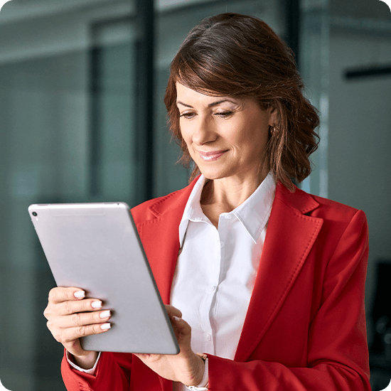 A woman confidently poses in a vibrant red suit, showcasing a professional and stylish appearance.
