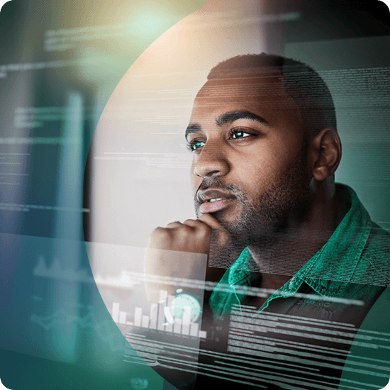 A man intently gazes at a computer screen displaying various data metrics and graphs.