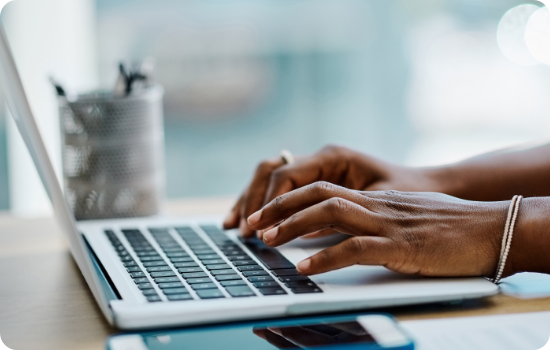 Hands typing on a laptop