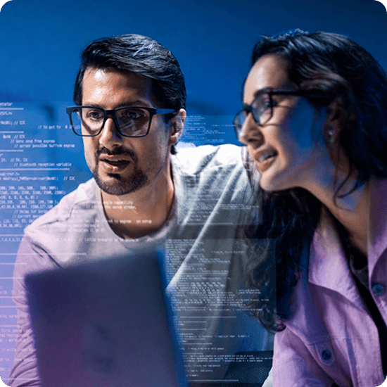 Two people wearing glasses look at a laptop screen with lines of computer code projected in front of them.