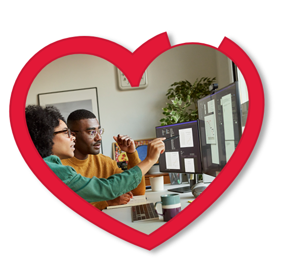 Two people having a conversation while looking at a desktop monitor