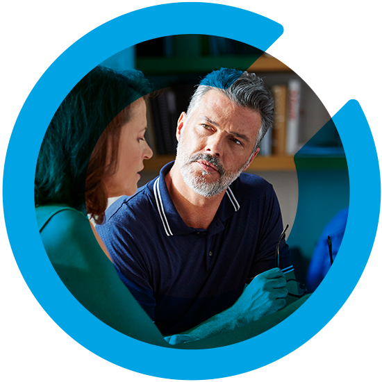 Two people discussing something in an office, with a blue C overlay