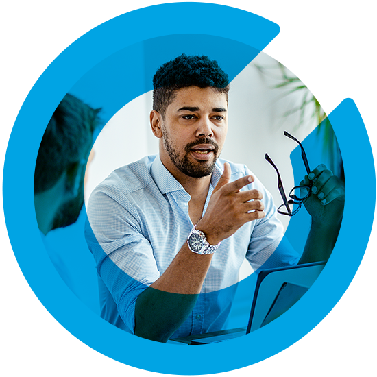 A man holding his glasses discussing something, with a blue C overlay