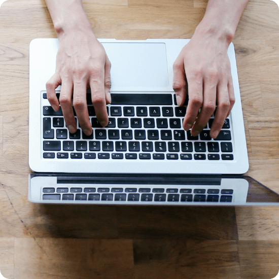 Hands typing on a laptop