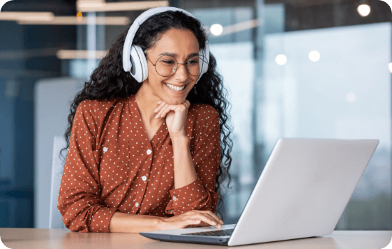 Woman with headphones in front of a laptop