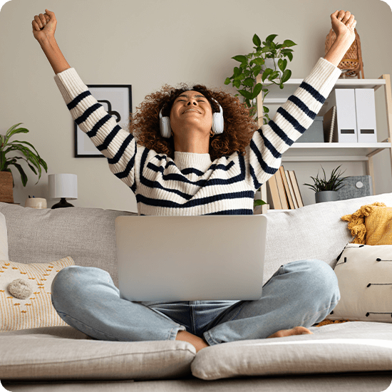 Person sitting on cushions with a laptop 