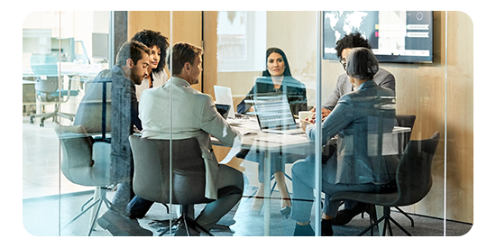 A group of employees huddled in a conference room