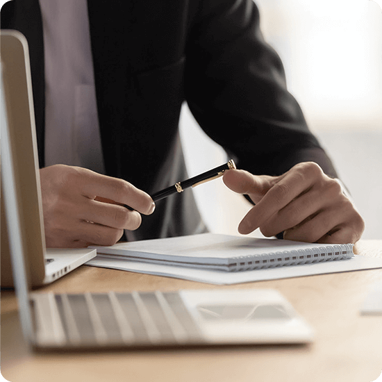 Laptop and man looking at papers