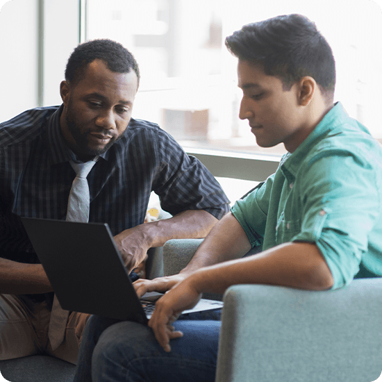 2 students looking over a laptop