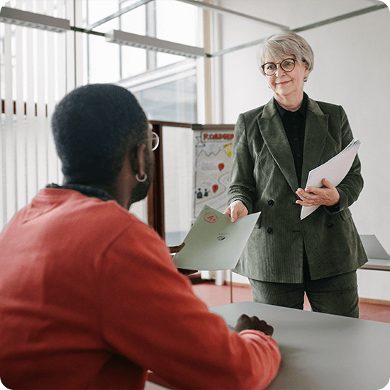 A teacher handing a graded paper to a student