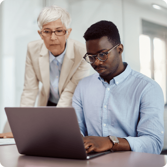 Two professionals looking over a laptop