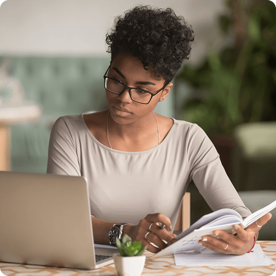 A woman with glasses looking at her laptop