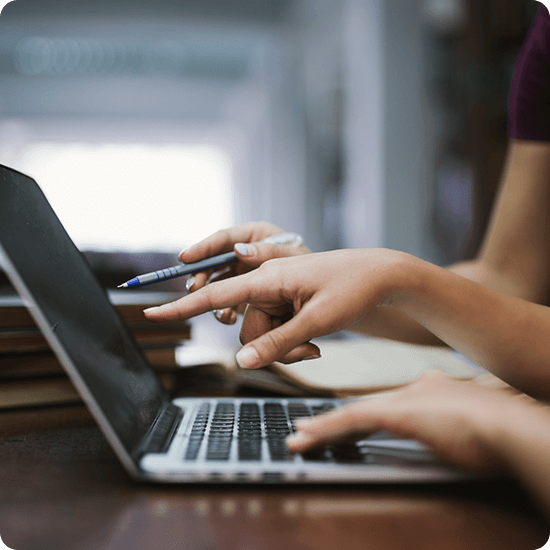 Hands typing on a laptop